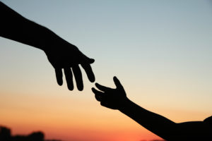 A father's hand reaching for a child's hand