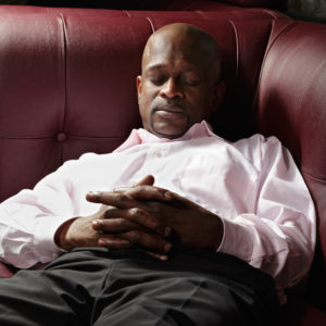 A man having nap on red leather sofa
