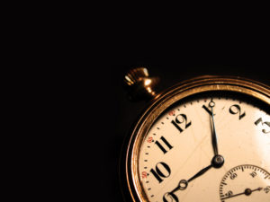 An antique pocket watch on a black background