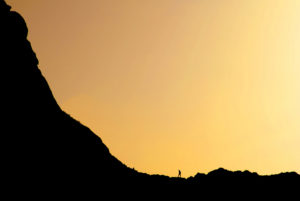 A man beginning a journey up the mountain at sunset