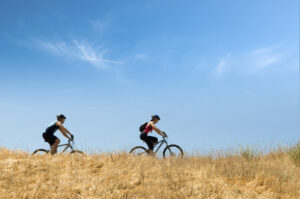 Two people bicycling on a hill