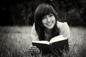 black and white photo of woman reading the bible