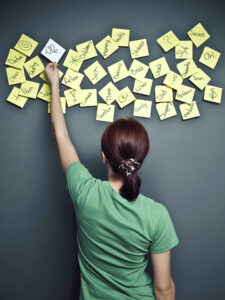 A woman putting post-it notes on the wall