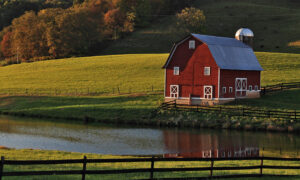 a red barn in a picturesque hillside setting