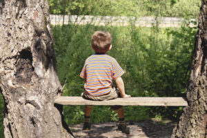 A young boy sitting on a bench