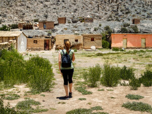 a woman walking towards an abandoned town