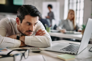 A bored man staring at his computer