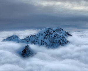 A snowy mountain range above the clouds