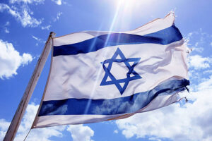 A tattered flag of Israel flying high in the sky