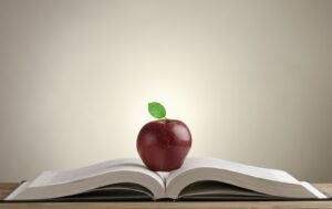 an apple on an open book